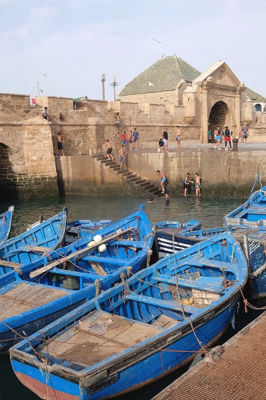 Barcos azuis junto a uma escadaria à beira de água